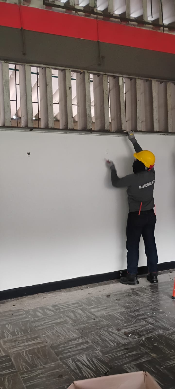 Trabajador de mantenimiento reparando un muro afectado por el sismo